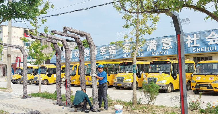 施工人员在黄潭小学门前附近安装公交站设施